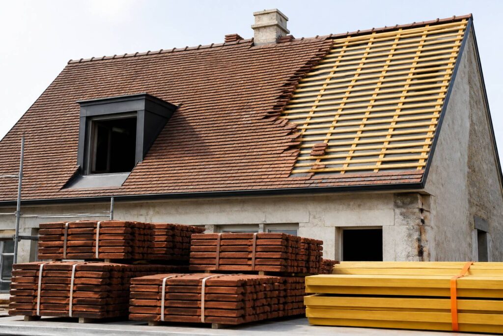 Toit en pente couvert de tuiles plates de petit format sur une maison ancienne